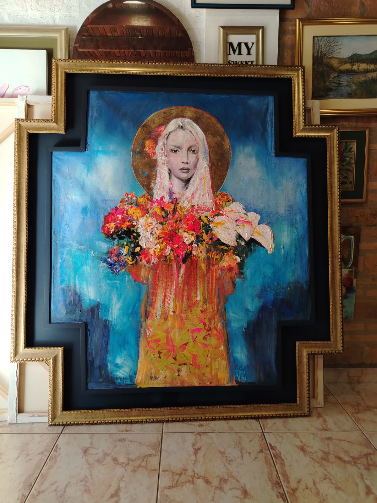 Obra en óleo con enmarcado artístico en tonos celestes.