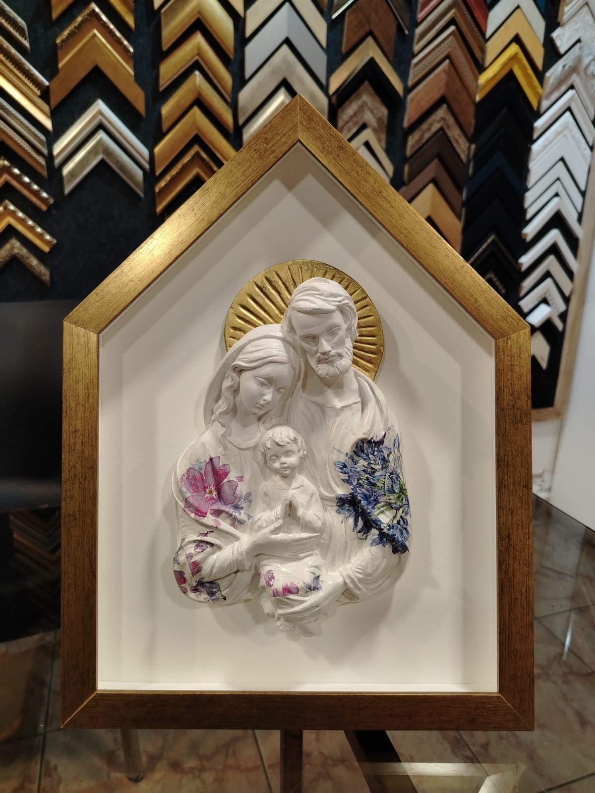 Escultura enmarcada con moldura dorada artesanal.