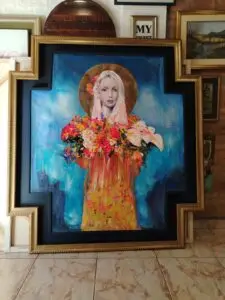 Cuadro artístico de figura femenina con flores, enmarcado con moldura dorada por Sol y Sombra SRL.