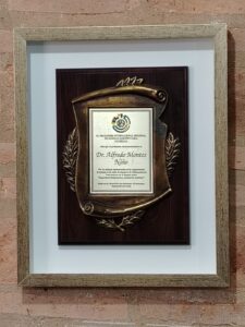 Placa de reconocimiento en relieve sobre base de madera, enmarcada con moldura rústica y passepartout blanco por Sol y Sombra SRL.