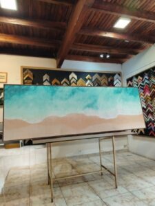 Pintura grande de playa con mar turquesa y arena beige, montada y enmarcada por Sol y Sombra SRL.