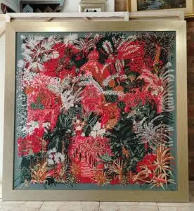 Marco dorado con cuadro artístico de tonos rojos y verdes, enmarcado por Sol y Sombra SRL.